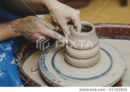 Woman hands on pottery wheel. Craftsman artist Woman hands on pottery wheel. Craftsman artist 61192604