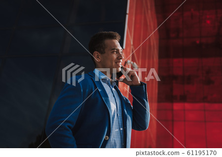 Cheerful guy making call outdoors stock photo Cheerful guy making call outdoors stock photo 61195170
