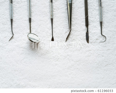 Set of a dental tool on a white hapkin. Close up. Set of a dental tool on a white hapkin. Close up. 61196033