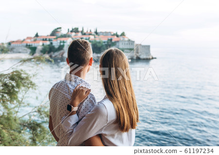 Couple looks at Sveti Stefan Couple looks at Sveti Stefan 61197234