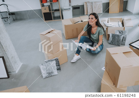 Happy young lady is looking up at her new home 61198248