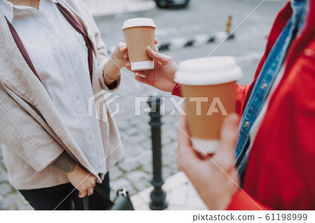Man giving hot drink for woman in the city 61198999