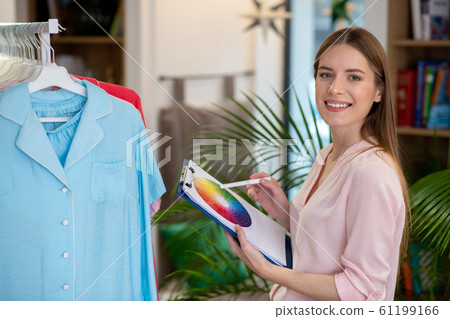 Successful designer girl in her office with a color palette in her hand. 61199166