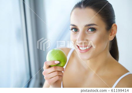 Woman Eating Apple. Beautiful Girl With White Teeth Biting Apple. High Resolution Image 61199414