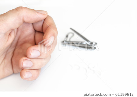 Trimmed nails of a young man. Closeup. 61199612