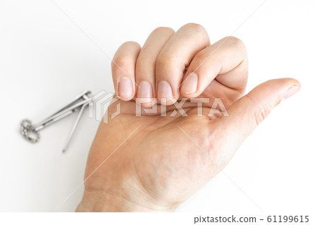 Trimmed nails of a young man. Closeup. 61199615