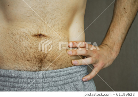 The hairy belly of a young man. 61199628