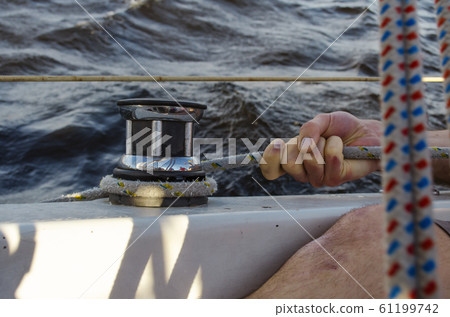 Handsome man working on sailboat. Water sport. 61199742