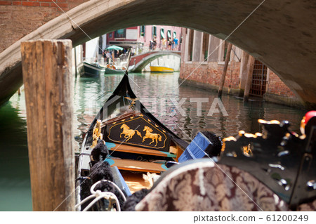 Walking on the traditional italian gondola by the canal. 61200249