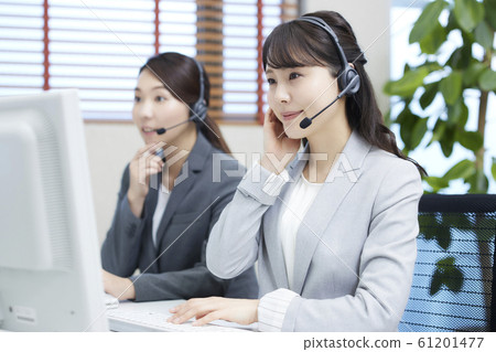 A young woman working at a call center: two operators 61201477