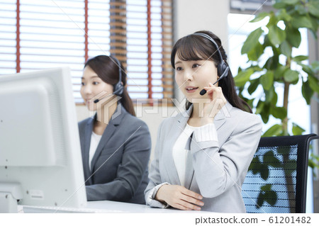 A young woman working at a call center: two operators 61201482