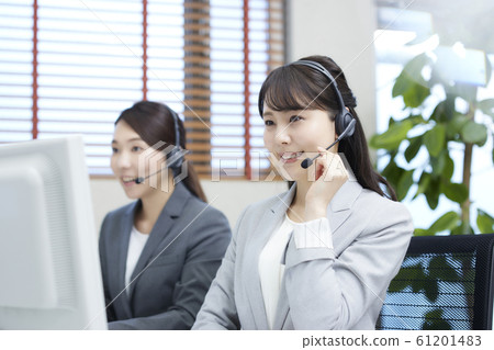 A young woman working at a call center: two operators A young woman working at a call center: two operators 61201483