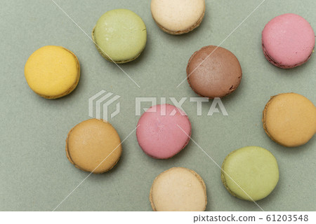 Colored tasty macaroons over a green background Colored tasty macaroons over a green background 61203548