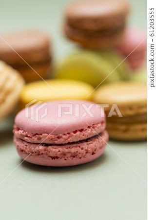 Colored tasty macaroons over a green background Colored tasty macaroons over a green background 61203555