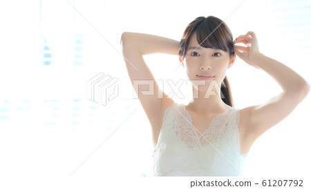 A woman tying her hair 61207792