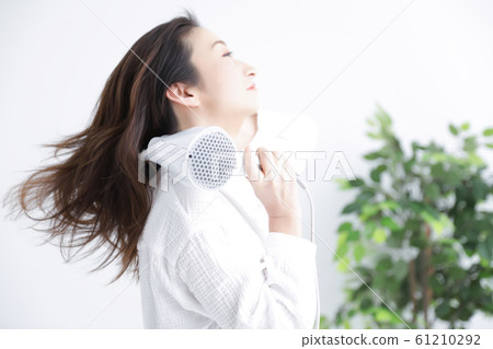 A woman using a hair dryer A woman using a hair dryer 61210292
