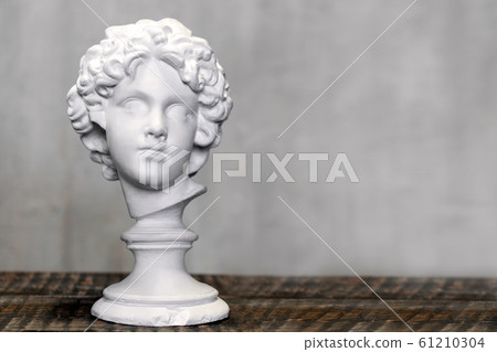 Young man bust, gypsum plaster sculpture. Copyspace for text 61210304