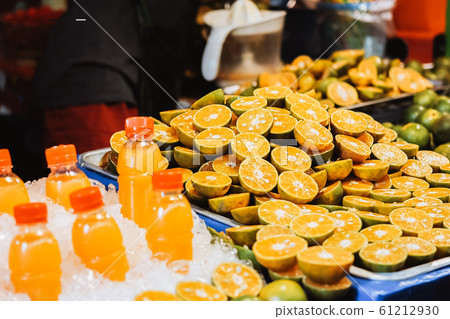 Fresh orange juice in bottle with Orange slices put on the table at local market. Fresh orange juice in bottle with Orange slices put on the table at local market. 61212930