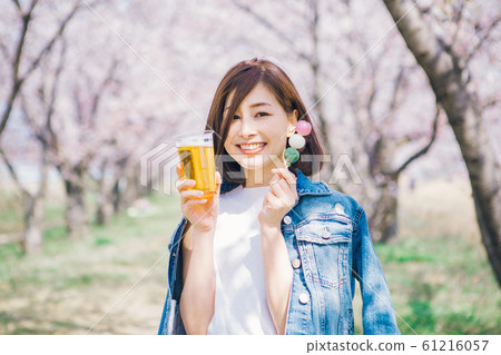 Woman drinking beer at cherry blossom viewing Woman drinking beer at cherry blossom viewing 61216057