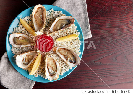 Platter of fresh opened oysters, top view. Platter of fresh opened oysters, top view. 61216588