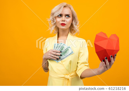 valentine's day concept. portrait of a thinking girl with red lips with a red heart made of paper valentine's day concept. portrait of a thinking girl with red lips with a red heart made of paper 61218216