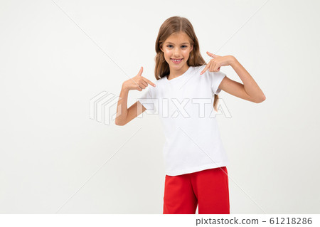 attractive caucasian young girl in a white t-shirt with a layout and red trousers on a white attractive caucasian young girl in a white t-shirt with a layout and red trousers on a white 61218286