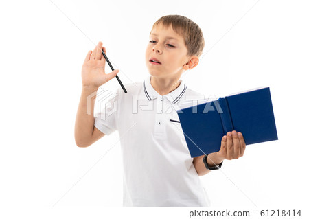 European boy thinks with a book and pen in his hands on a white background European boy thinks with a book and pen in his hands on a white background 61218414