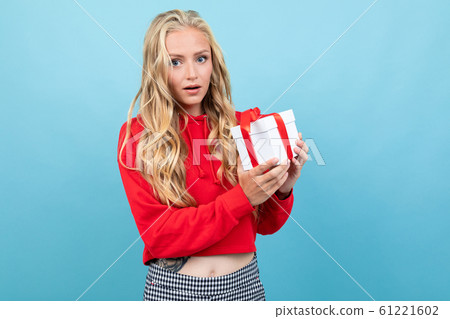 valentine's day concept. blond girl holding a gift in her hands on a light blue background 61221602