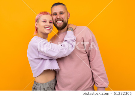 happy smiling couple of girl and guy with colored hair and piercing are standing in an embrace on a happy smiling couple of girl and guy with colored hair and piercing are standing in an embrace on a 61222305