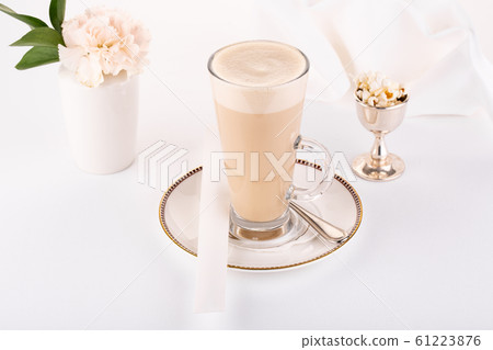 Coffee latte with beige flower in glass and popcorn Coffee latte with beige flower in glass and popcorn 61223876