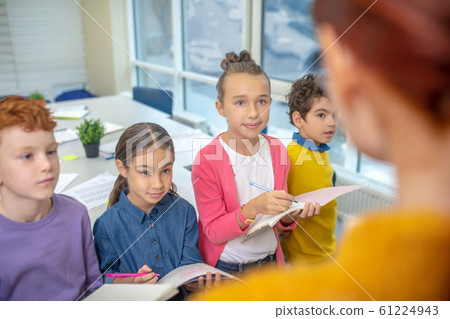Children listening to the teacher and taking notes Children listening to the teacher and taking notes 61224943