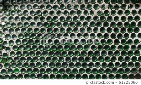 A wall of green wine bottles. Solid texture fence from the bottom A wall of green wine bottles. Solid texture fence from the bottom 61225060