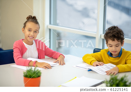 Boy and a girl preparing their homework together Boy and a girl preparing their homework together 61225141