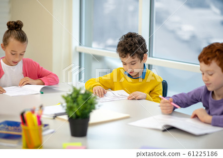 Three kids studying at the class together Three kids studying at the class together 61225186