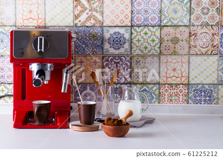 Home espresso machine on kitchen countertop with two cups, milk and sugar on sticks. Making coffee at home. Home espresso machine on kitchen countertop with two cups, milk and sugar on sticks. Making coffee at home. 61225212