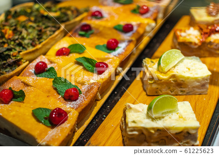 Pastry shop with variety of donuts, muffins, creme brulee, cakes with fruits and berries Pastry shop with variety of donuts, muffins, creme brulee, cakes with fruits and berries 61225623
