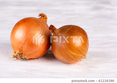 Bulb brown onions on white wooden background 61226390
