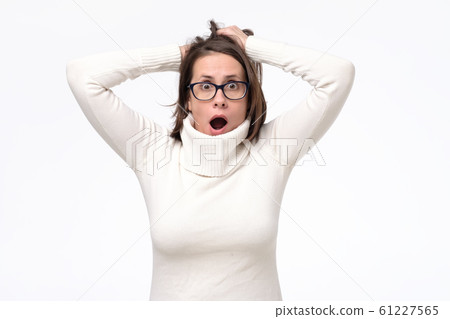 Young caucasian woman in glasses with shocked facial expression being amazed with news Young caucasian woman in glasses with shocked facial expression being amazed with news 61227565