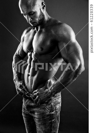 Shirtless muscled fitness man. Cool looking. Tough guy. Bald. Tanned skin. Studio shot on black background. 61228339