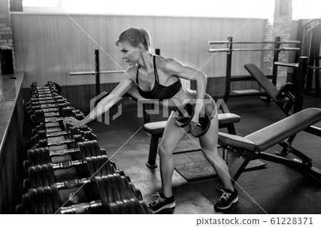 Fitness girl lifting dumbbell 61228371