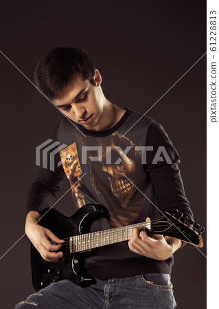 Handsome man playing electro guitar, studio shot Handsome man playing electro guitar, studio shot 61228813