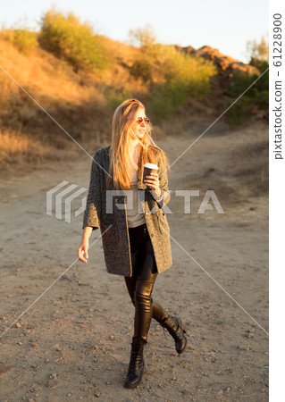 pretty girl sitting in street with morning coffee pretty girl sitting in street with morning coffee 61228900