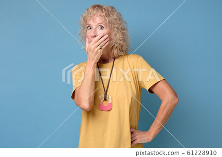 Scared woman looks at camera covering mouth with hands feel horrified Scared woman looks at camera covering mouth with hands feel horrified 61228910