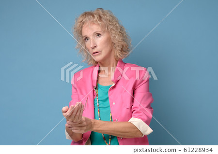 Woman checking her pulse being worried by tachycardia. 61228934