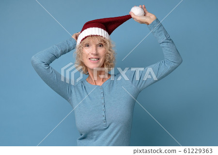 Pretty christmas woman in red santa hat, smiling isolated on blue background 61229363