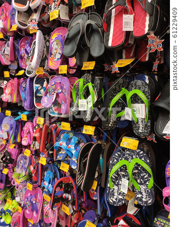 Different type of shoes and slippers piled up in one place and sell them to customers. It comes in a variety of brands, designs and sizes. 61229409