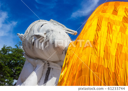 Reclining buddha statue on blue sky background Reclining buddha statue on blue sky background 61233744