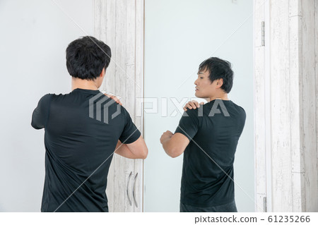 A man checking his body in front of a mirror A man checking his body in front of a mirror 61235266