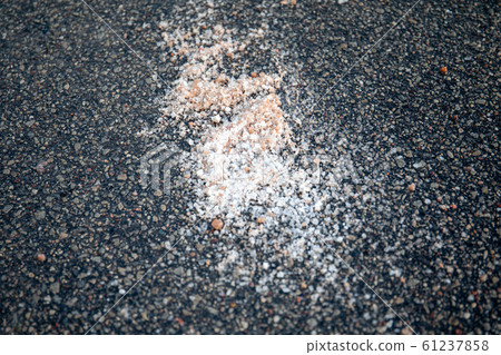 Salt spilled on the pavement. Winter season Salt spilled on the pavement. Winter season 61237858