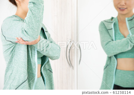 Woman checking body with mirror 61238114